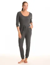 Enterito de tejido de punto con textura canalé, color gris oscuro. Presenta escote redondo, mangas tres cuartos y cintura elastizada con lazo de ajuste. La parte inferior tiene un calce relajado tipo jogger con puños elastizados y bolsillos laterales.