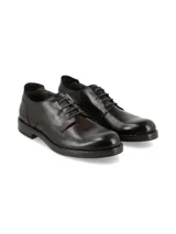Zapato de vestir tipo oxford para hombre, confeccionado en cuero italiano de color marrón oscuro con acabado pulido. Presenta cierre mediante cordones, punta redonda y suela de poliuretano con tacón bajo.
