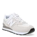 Championes urbanos New Balance modelo 574, color gris claro con detalles en blanco. Confeccionados en una combinación de gamuza y malla, presentan el logo N característico en los laterales y entresuela con tecnología ENCAP para mayor amortiguación.