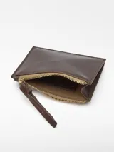 Monedero mediano de piel bovina de curtición vegetal, color rojo, con textura craquelada. Posee un compartimento principal con cierre de cremallera y un tarjetero en la parte trasera.