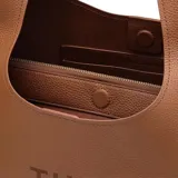Cartera tipo hobo Marc Jacobs modelo The Sack, confeccionada en cuero premium color marrón con textura granulada. Presenta el logo de la marca estampado en el frente y una correa integrada para llevar al hombro.