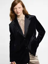 Blazer negro de terciopelo con solapa de satén y cierre con dos botones.