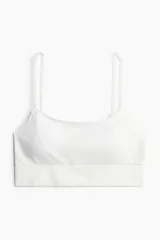Bralette de diseño seamless, color blanco, con breteles finos ajustables, banda inferior acanalada y copas con relleno extraíble.