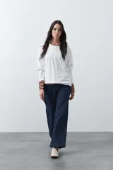 Remera de manga larga en color blanco, con calce relajado y diseño minimalista. Presenta un cuello redondo clásico y puños rectos, ideal para usar como prenda base en capas.