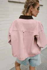Cazadora de denim efecto lavado color rosado, con cuello solapa de pana marrón, cierre frontal con botones metálicos y bolsillos delanteros de plastrón.