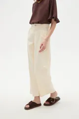 Pantalon de jean estilo barrel, color natural, de tiro medio con bolsillos laterales y cierre frontal.