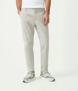 Pantalón de vestir color marrón, de corte slim y largo cropped. Confeccionado en tejido de algodón liso, con bolsillos laterales y traseros. Cierre frontal con botón y cremallera.