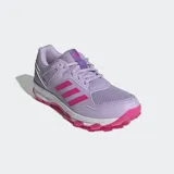 Championes de hockey Adidas Fabela Rise para mujer, color violeta con las tres tiras características en fucsia. Presentan un diseño con exterior de malla transpirable, refuerzos sintéticos para mayor soporte, mediasuela de EVA para amortiguación y suela Traxion con tapones para un agarre óptimo en la cancha.