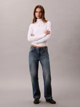 Top de manga larga Calvin Klein color blanco, confeccionado en punto fino de algodón y licra. Presenta cuello tortuga, ajuste ceñido al cuerpo y un pequeño parche con el monograma de la marca en el pecho.