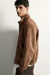 Cazadora bomber de corte regular fit en tejido efecto ante de color marrón oscuro, con cuello alto, cierre frontal de cremallera y bolsillos laterales de vivo.