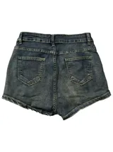 Short de denim tiro bajo con diseño cruzado en la cintura, efecto desgastado y detalles de ojalillos metálicos dorados.