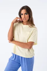 Remera color amarillo pastel de viscosa, con cuello redondo y bolsillo de encaje en el pecho.