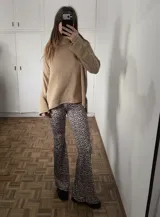 Calza de tiro alto con diseño acampanado y estampado animal print de leopardo en tonos grises y negros.