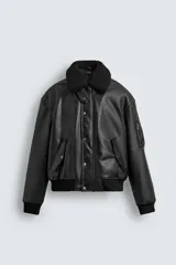 Cazadora estilo bomber de corte relajado confeccionada en tejido efecto piel. Presenta cuello de solapa con forro de pelo sintético desmontable, cierre frontal de cremallera oculta por solapa con botones a presión, bolsillos laterales con solapa y puños y bajo acabados en rib.
