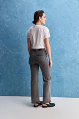 Jean de tiro alto con corte recto, confeccionado en denim con spandex. Presenta un lavado gris oscuro con efecto desgastado, cierre frontal con botón y bolsillos laterales y traseros.
