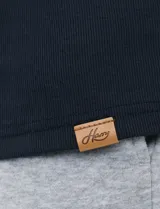 Remera de manga larga con cuello polo, confeccionada en tejido de punto canalé francés. Presenta abotonadura frontal con botones de madera y detalles a contratono en la cartera y el interior del cuello.