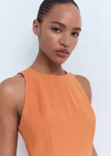 Vestido midi de corte evasé, sin mangas, con cuello caja y cierre posterior de cremallera y botón.