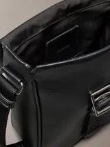Morral Calvin Klein modelo Cargo Reporter, color negro, confeccionado en poliuretano con diseño estructurado, solapa frontal y cierre de hebilla. Cuenta con correa de hombro ajustable y detalles de la marca grabados.