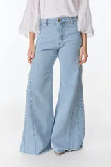 Pantalón de pierna ancha con acabado brillante, confeccionado en lino. Presenta un diseño de tiro medio con cierre de botón y cremallera, bolsillos traseros y etiqueta de marca en la cintura.