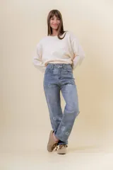 Pantalón de jean de corte recto y relajado, con tiro medio-alto. Presenta un estampado floral sutil en tonos claros sobre la base de denim azul y cuenta con interior forrado para mayor abrigo.