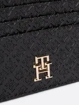 Tarjetero Tommy Hilfiger negro con diseño integral del monograma TH en bajo relieve. Cuenta con un compartimento principal con cremallera y múltiples ranuras exteriores para tarjetas.