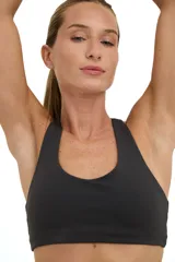 Top deportivo gris oscuro con escote medio redondeado y espalda deportiva con diseño de mariposa.