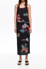 Falda midi de corte recto con cintura elástica y estampado de paisajes marinos en tonos coloridos sobre base negra.