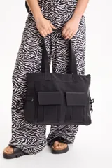 Cartera tipo bolso de poliuretano color negro, con doble asa de hombro y dos bolsillos frontales con solapa.
