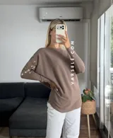 Sweater color marrón de manga murciélago oversize, con escote barco y bordado de lentejuelas y canutillos al tono en hombros y mangas.