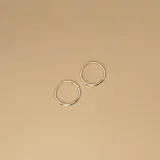 Par de aros tipo argolla de diseño clásico y minimalista, fabricados en plata 925 con acabado pulido.