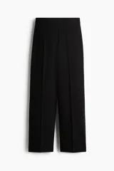 Pantalón sastrero de tiro alto y piernas amplias con pliegues en la parte delantera y trasera, en color negro.