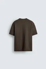 Camiseta de corte relajado confeccionada en tejido interlock de algodón con elasticidad, presenta cuello redondo y manga corta.
