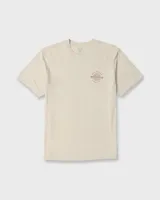 Remera Billabong de manga corta y corte regular, color beige, con gran estampado gráfico en la espalda que incluye el texto "Billabong", la ilustración de una quilla de tabla de surf y un sol estilizado.