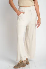 Pantalón de corte recto y holgado, confeccionado en tejido liviano color arena con textura jaspeada. Presenta cintura elástica con cordón interno, bolsillos frontales tipo parche y un calce fluido.