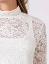 Blusa de encaje negro con cuello alto y mangas largas. Incluye musculosa interna a tono para mayor cobertura.