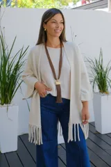 Saco abierto de corte recto y holgado, color visón, con mangas tres cuartos y detalle de flecos largos en el ruedo.