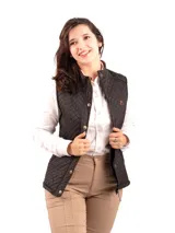 Chaleco capitoneado color rosa claro, con cuello alto, cierre frontal con botones a presión y logo bordado en el pecho.