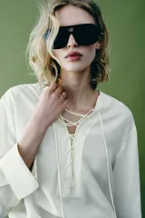 Camisa blanca ZARA Woman Collection de 100% seda, con escote en V ajustable con cordones entrelazados y manga larga con puños rectos.