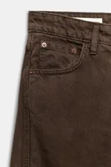 Jeans de tiro medio color marrón con diseño de volumen crop, silueta holgada en las piernas y cinco bolsillos tradicionales. Cierre frontal con cremallera y botón metálico.