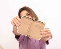 Billetera de cuero color visón con diseño acolchado de costuras cuadradas y cierre metálico perimetral.