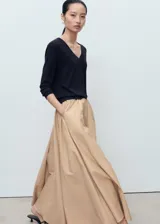 Jersey de punto fino color negro, con cuello en pico y manga larga. Presenta un diseño recto y minimalista.