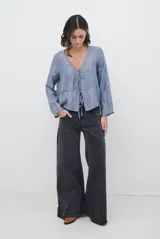 Chaqueta ligera de manga larga en color azul, con escote en V y cierre frontal mediante dos lazos ajustables. Presenta un diseño fluido con textura sutil y corte recto.