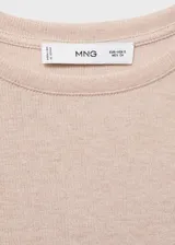 Camiseta de punto fino con acabado de lúrex, cuello redondo y manga larga. Presenta un diseño recto y entallado.