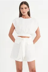 Blusa blanca crop top con mangas cortas amplias y cintura elastizada.