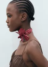 Vestido midi de tirantes finos, con diseño recto y escote con detalle de lazo. Presenta un acabado con efecto arrugado y corte holgado.