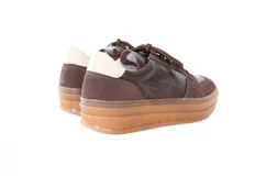 Championes urbanos confeccionados en una combinación de cuero y gamuza en tono marrón chocolate, con suela tipo plataforma y cordones al tono.
