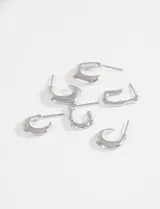 Set de tres pares de aros plateados con diferentes diseños texturizados y formas onduladas.