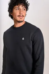 Buzo de cuello redondo en color negro, con diseño liso y pequeño logo bordado en el pecho.