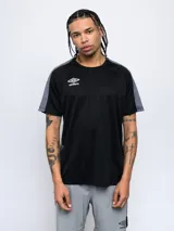 Remera deportiva Umbro de manga corta, color negro con paneles laterales en gris texturizado. Presenta cuello redondo y logo de la marca estampado en blanco en el pecho.