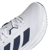 Championes de running Adidas Galaxy 7, color blanco con las tres tiras laterales en azul marino. Presentan una estructura de malla transpirable y entresuela con tecnología Cloudfoam para mayor amortiguación.